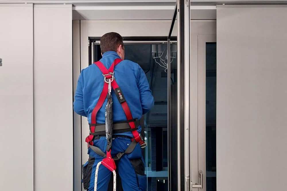 Monteur steht an einem Fenster und prüft die Sonnenschutzanlage.